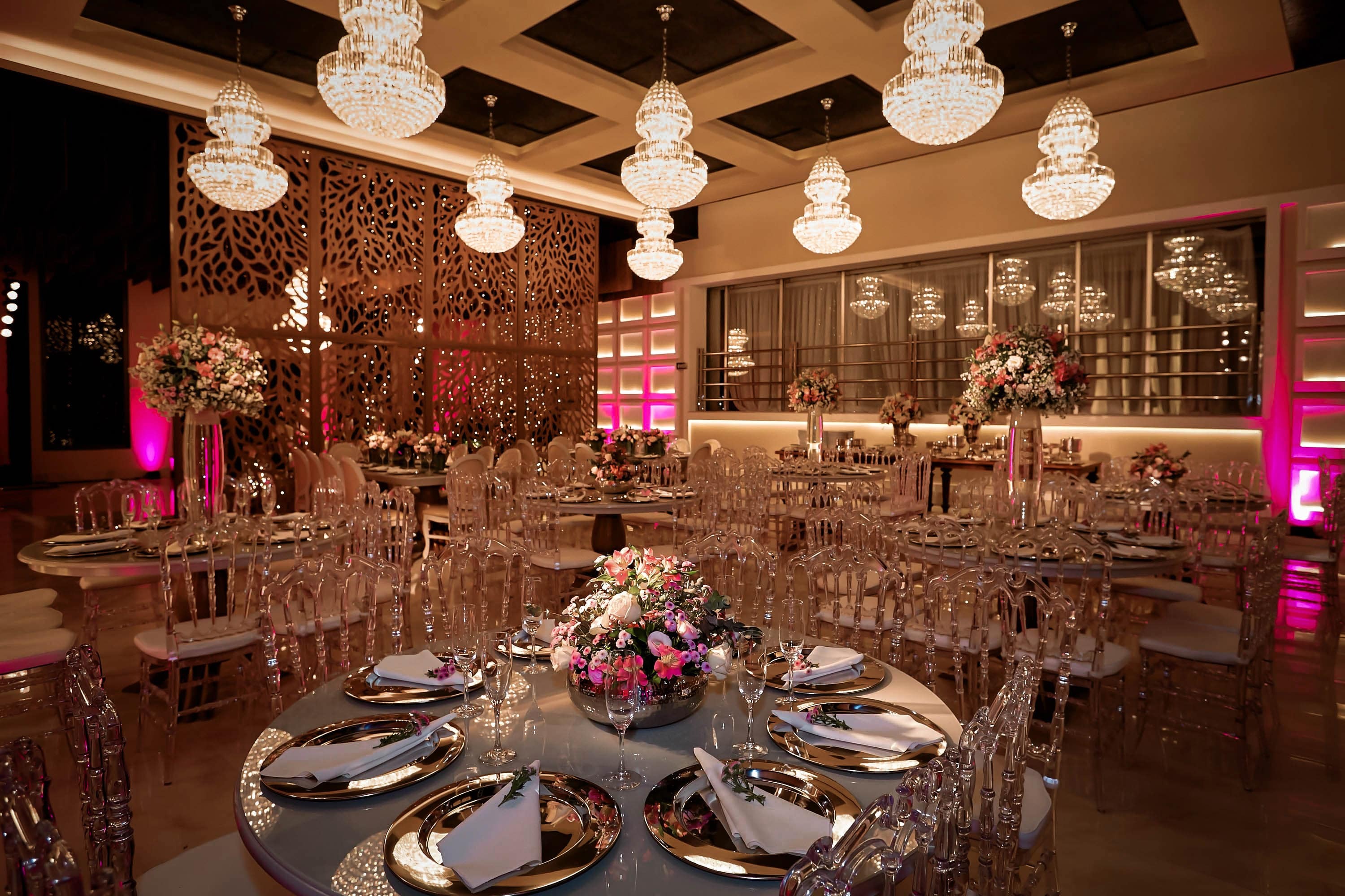 Salão Ballroom decorado com lustres, mesas postas e iluminação de festa